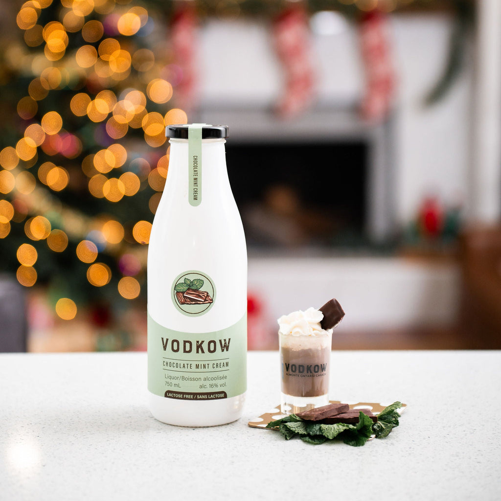 Bottle of Vodkow on a table with a festive background featuring a Christmas tree.